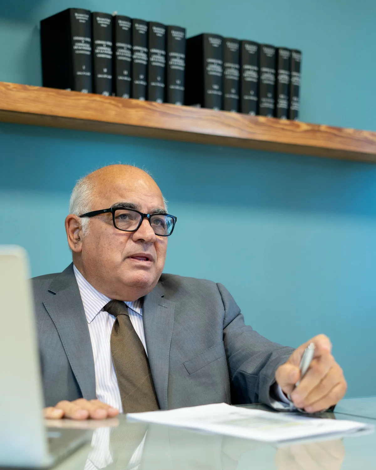 El Dr. Arturo Araujo trabajando en el estudio, frente a la biblioteca con los tomos del Código Civil y Comercial de la Nación