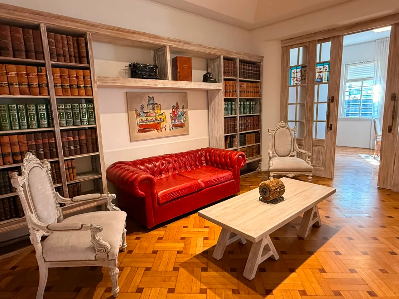 Sala de espera del estudio Araujo Abogados, con biblioteca jurídica y sillón Chesterfield